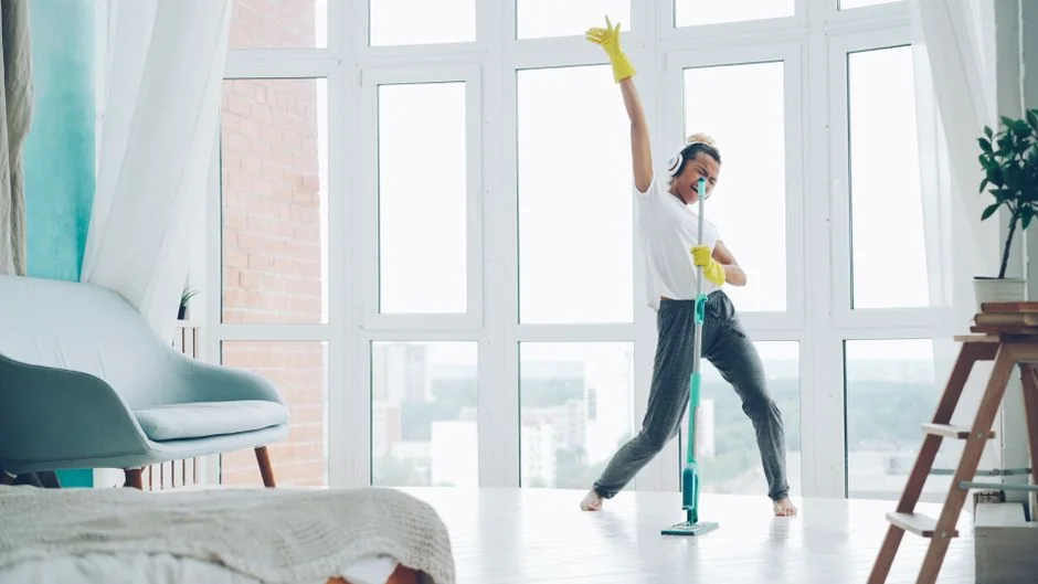 A couple working together to lift a couch as they move into a new apartment.